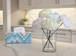 DIY paper flowers made out of Kleenex in a vase next to a box of Kleenex tissues